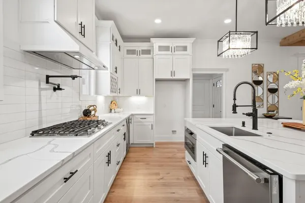 a kitchen with stainless steel appliances kitchen island granite countertop a sink a stove a dining table and chairs
