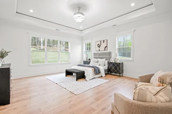a bedroom with a large bed and wooden floor
