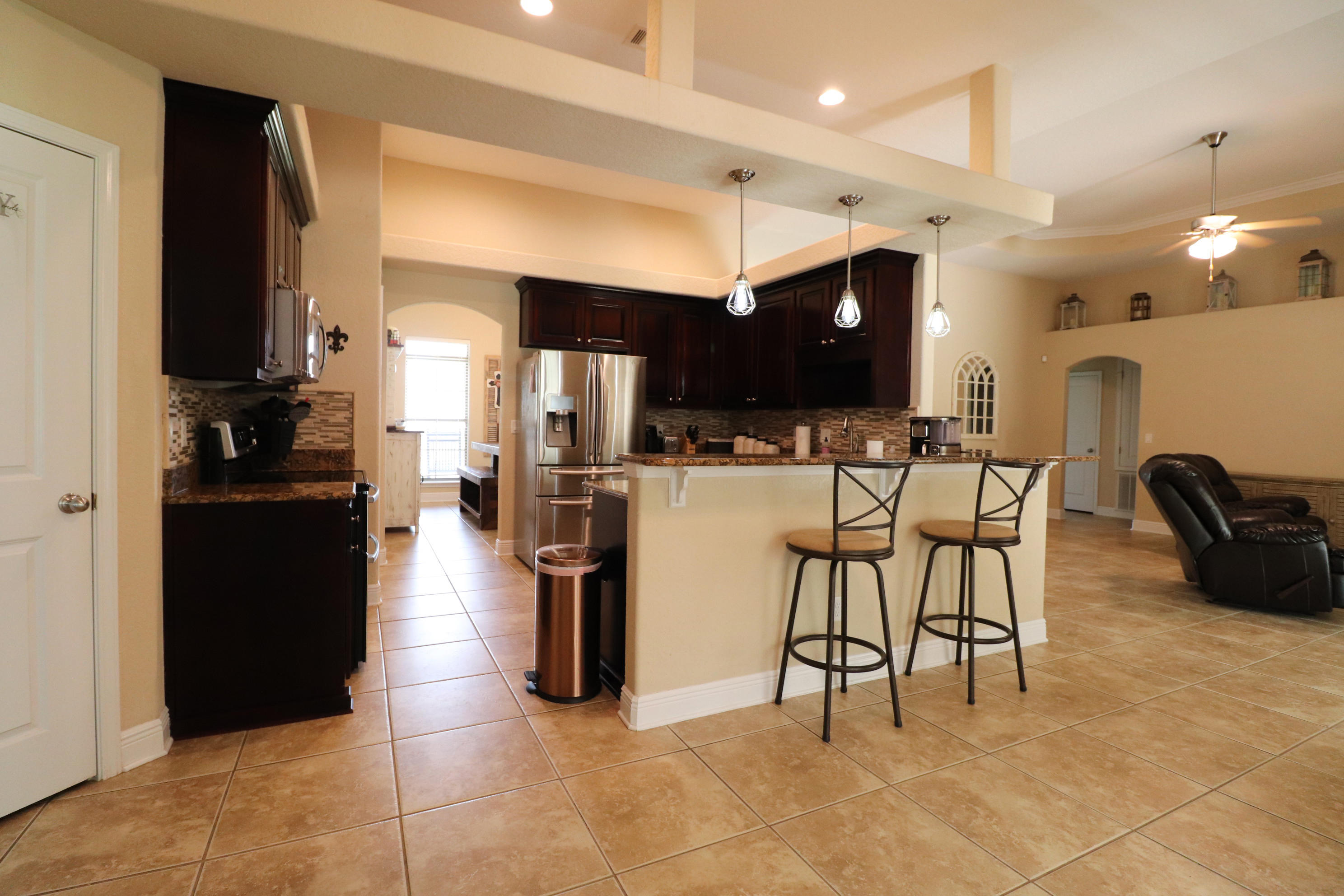 6181 Hummingbird Lane Crestview, FL 32536 - Photo 17 of 56 a kitchen with stainless steel appliances kitchen island granite countertop a refrigerator and a stove top oven