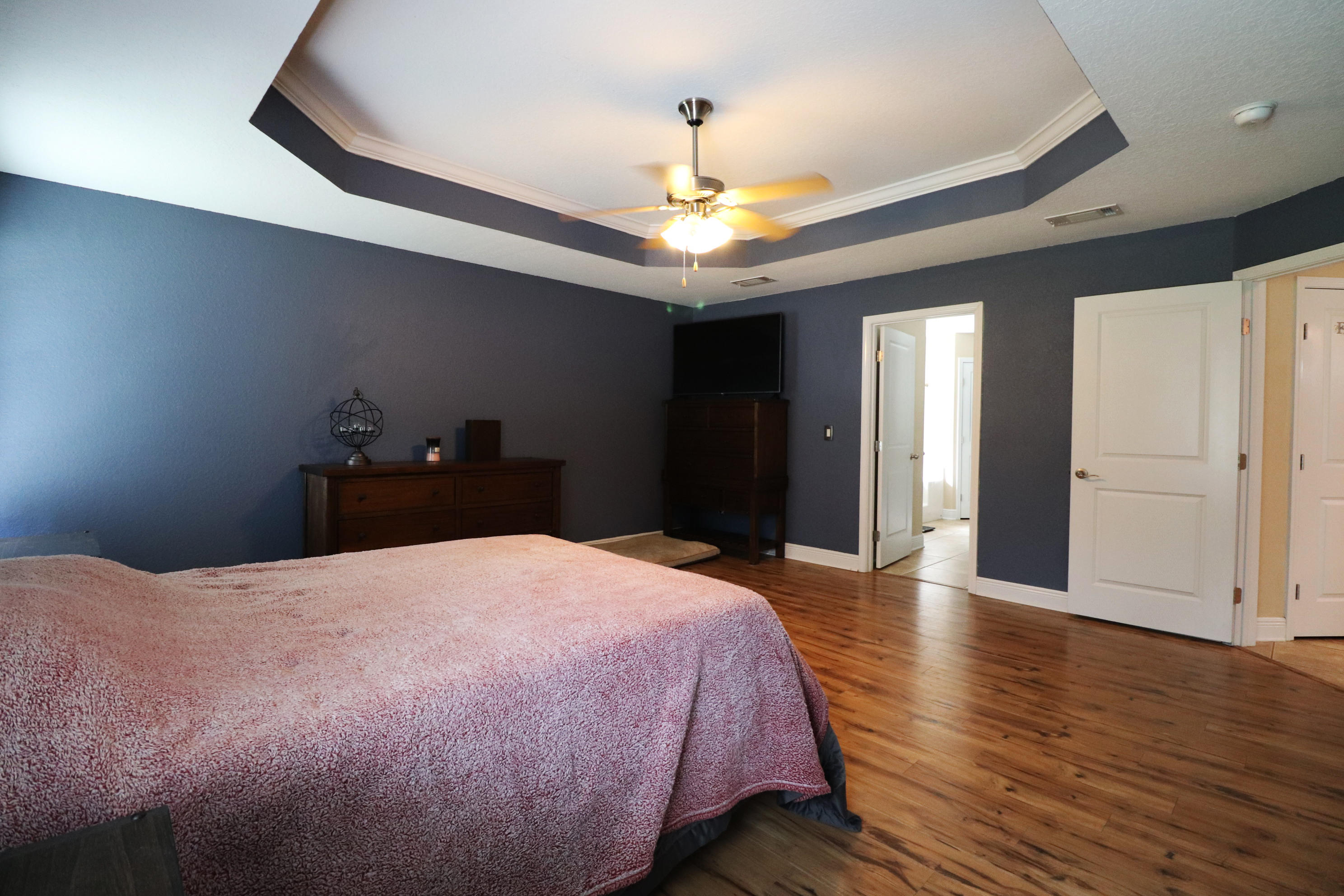 6181 Hummingbird Lane Crestview, FL 32536 - Photo 24 of 56 a bedroom with a bed and wooden floor