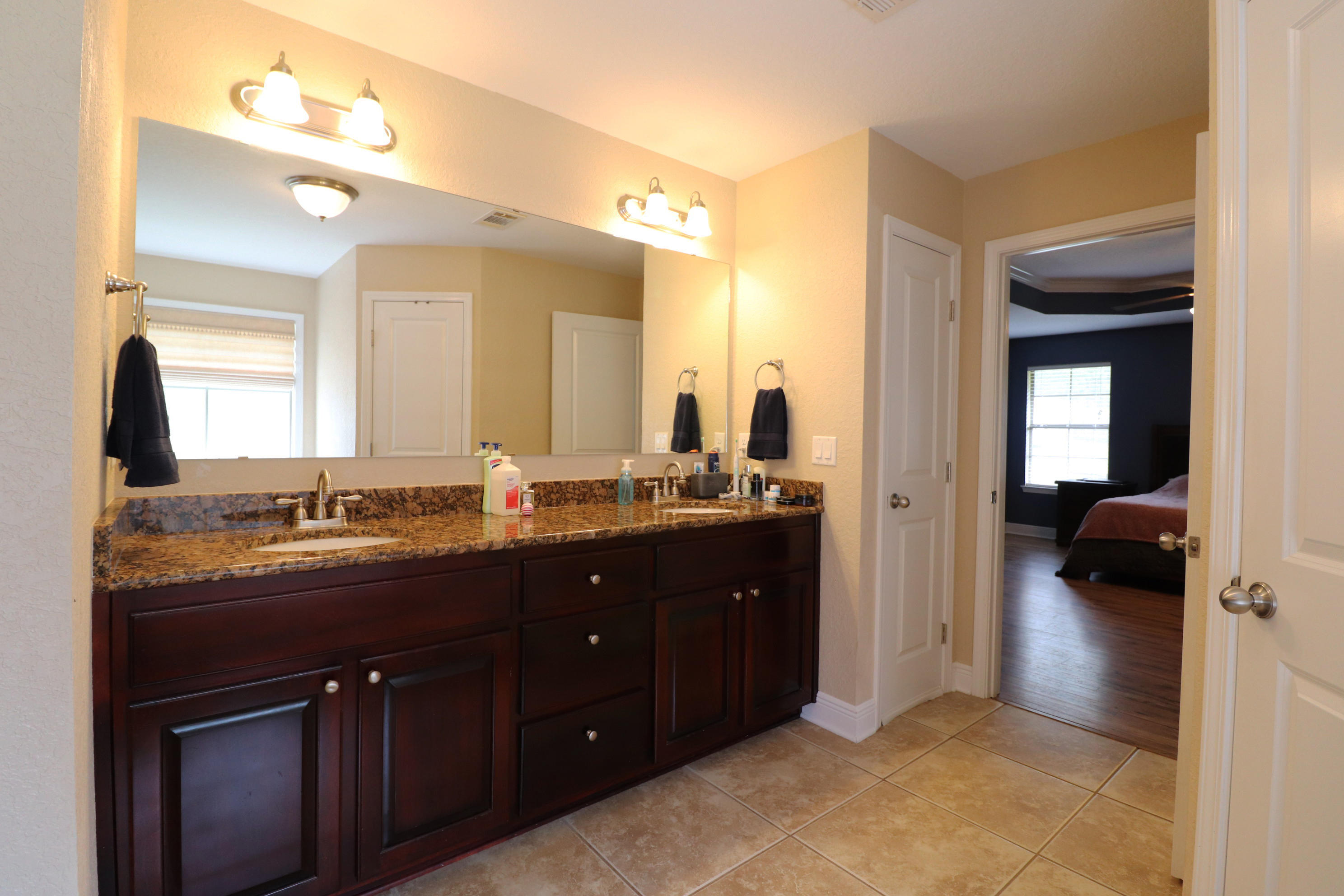 6181 Hummingbird Lane Crestview, FL 32536 - Photo 29 of 56 a en suite bathroom with a granite countertop sink and mirror