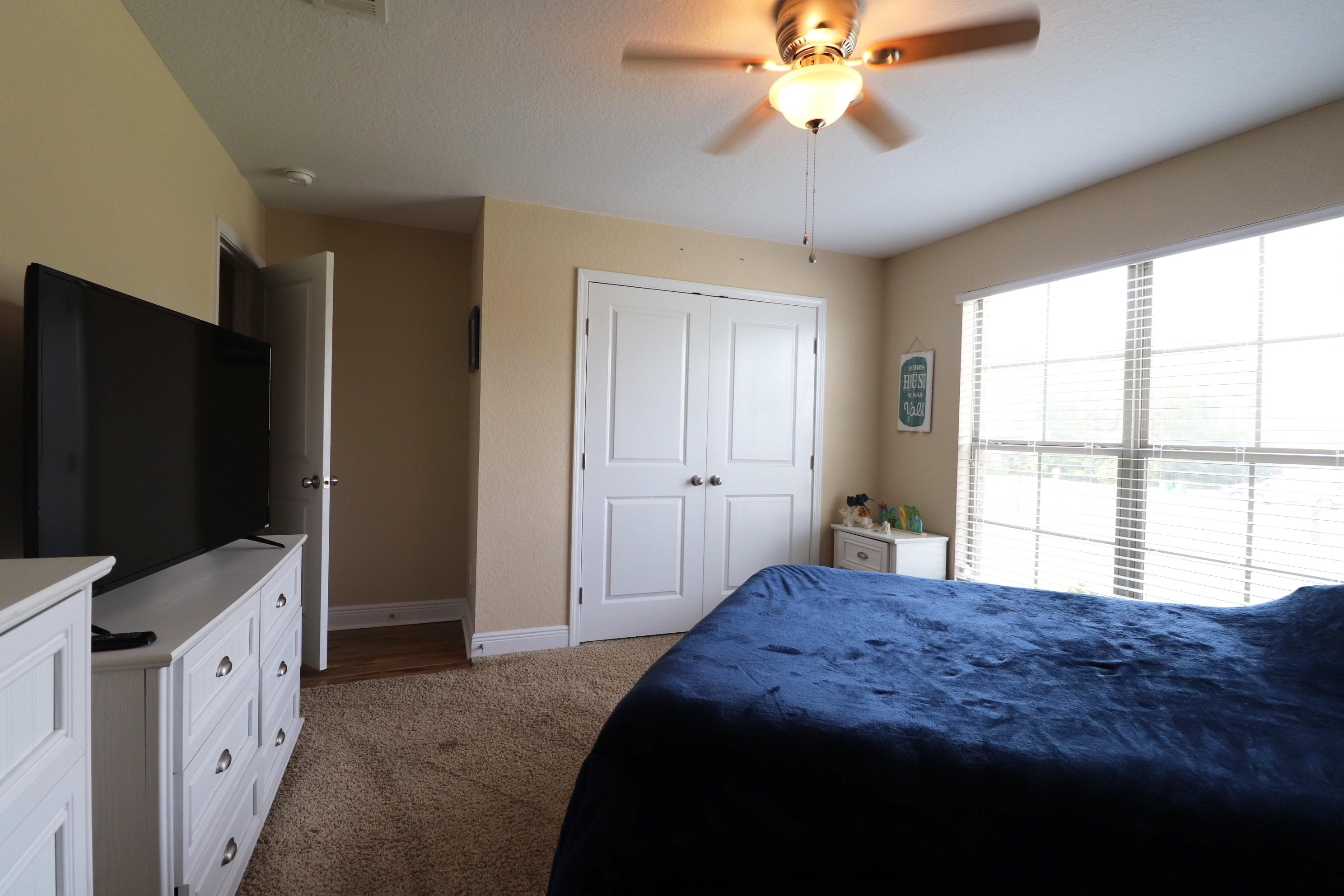 6181 Hummingbird Lane Crestview, FL 32536 - Photo 31 of 56 a spacious bedroom with a bed and a chandelier