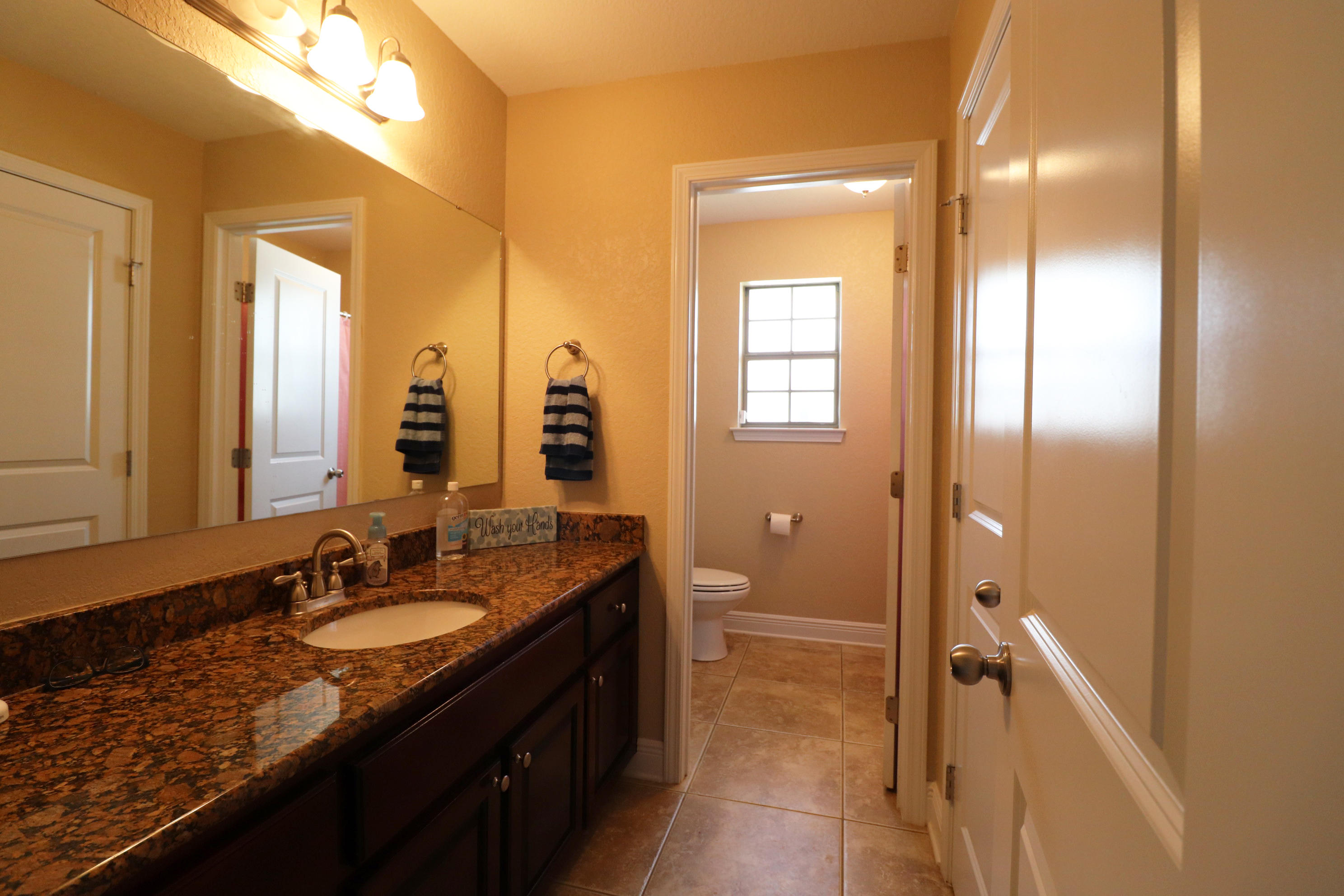 6181 Hummingbird Lane Crestview, FL 32536 - Photo 32 of 56 a bathroom with a granite countertop sink and a mirror