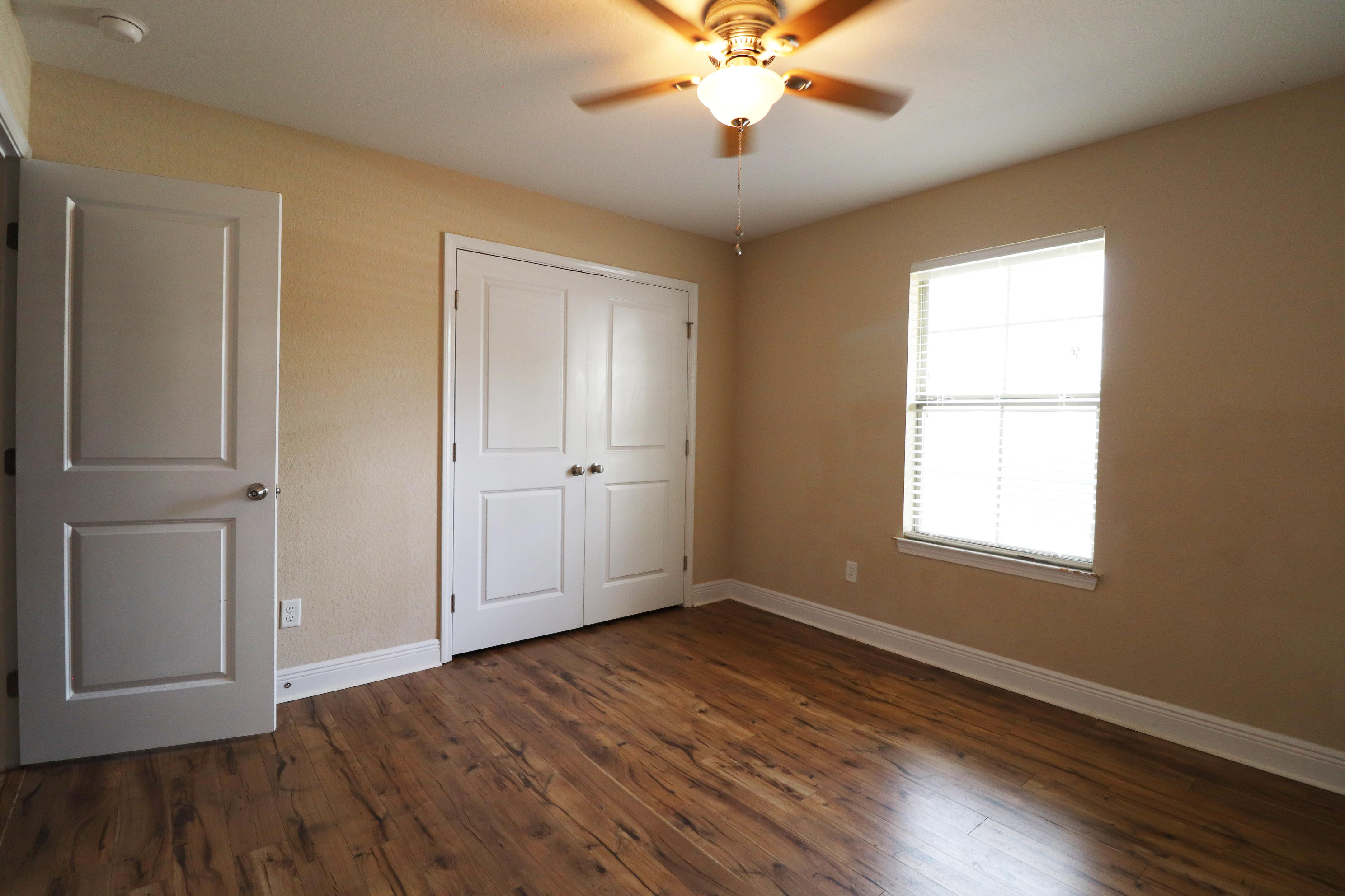 6181 Hummingbird Lane Crestview, FL 32536 - Photo 34 of 56 a view of an empty room with wooden floor and a window