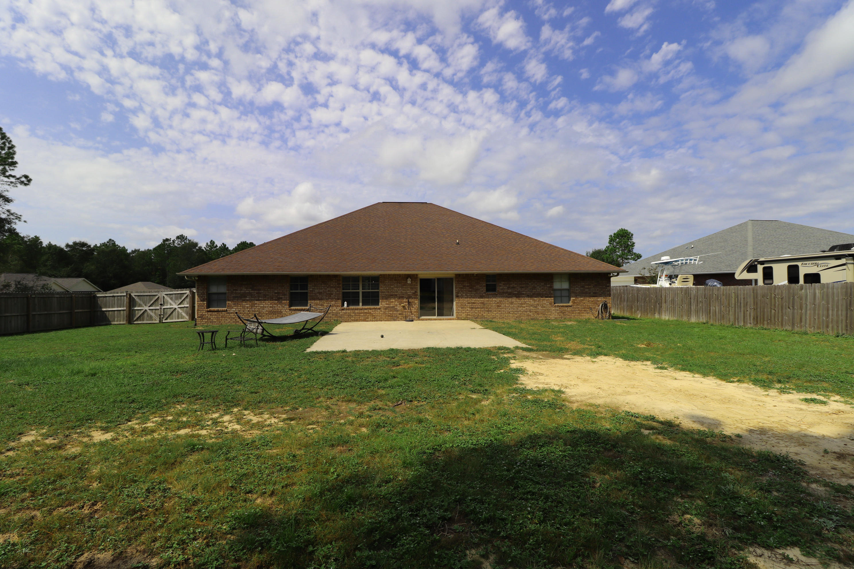 6181 Hummingbird Lane Crestview, FL 32536 - Photo 40 of 56 a backyard of a house with table and chairs