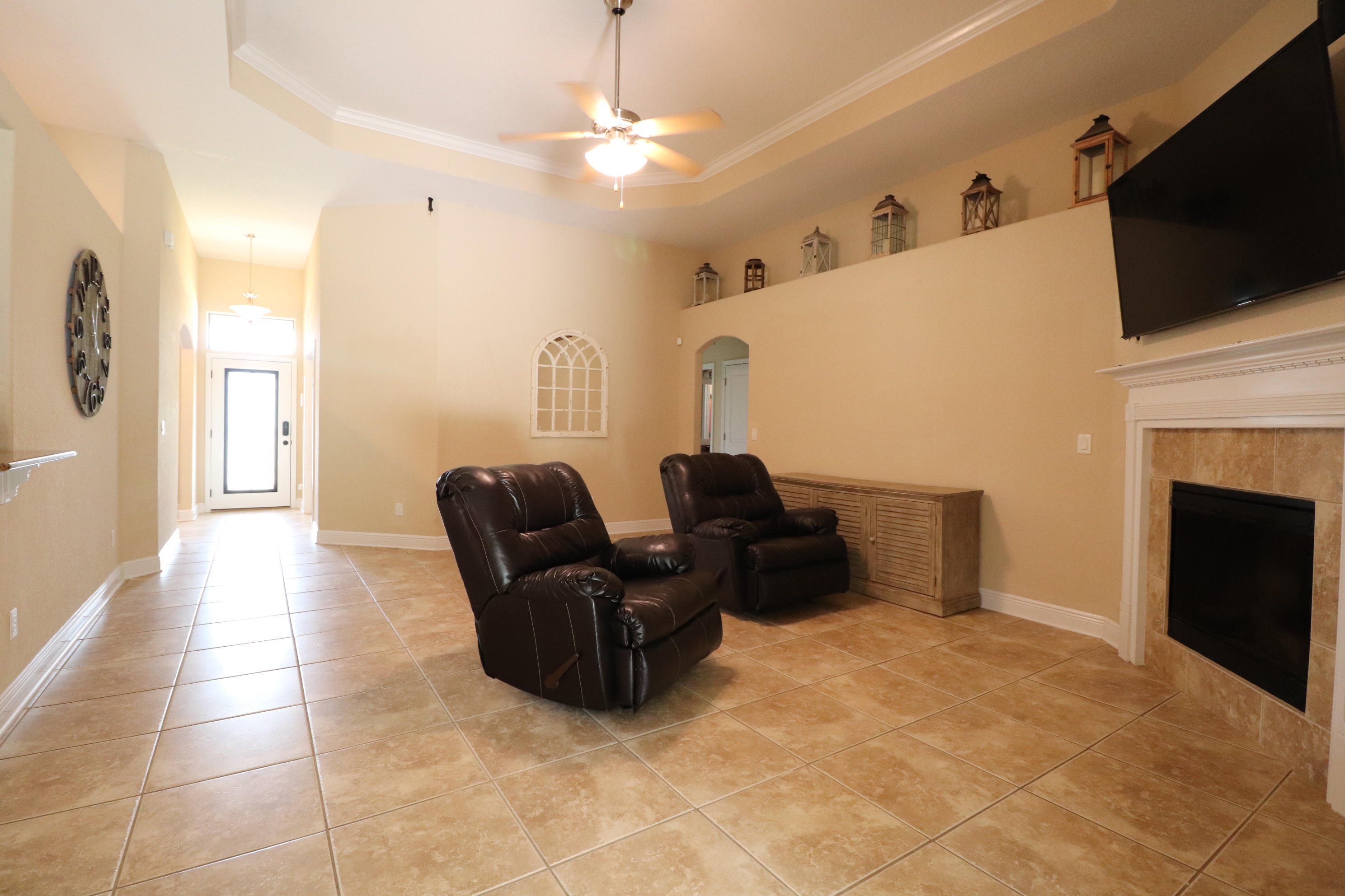 6181 Hummingbird Lane Crestview, FL 32536 - Photo 10 of 56 a living room with furniture a flat screen tv and a fireplace