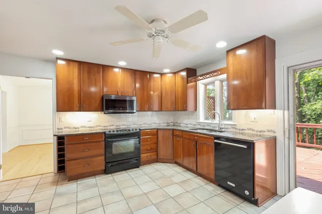 a large kitchen with stainless steel appliances granite countertop a stove a sink and a microwave
