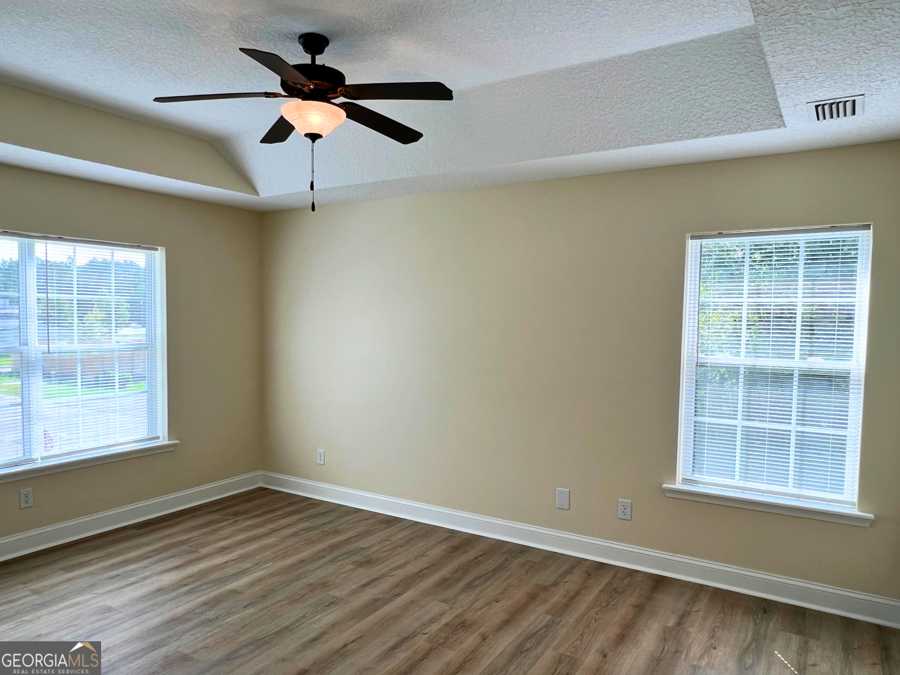 822 Davis Avenue Kingsland, GA 31548 - Photo 16 of 24 an empty room with wooden floor ceiling fan and windows