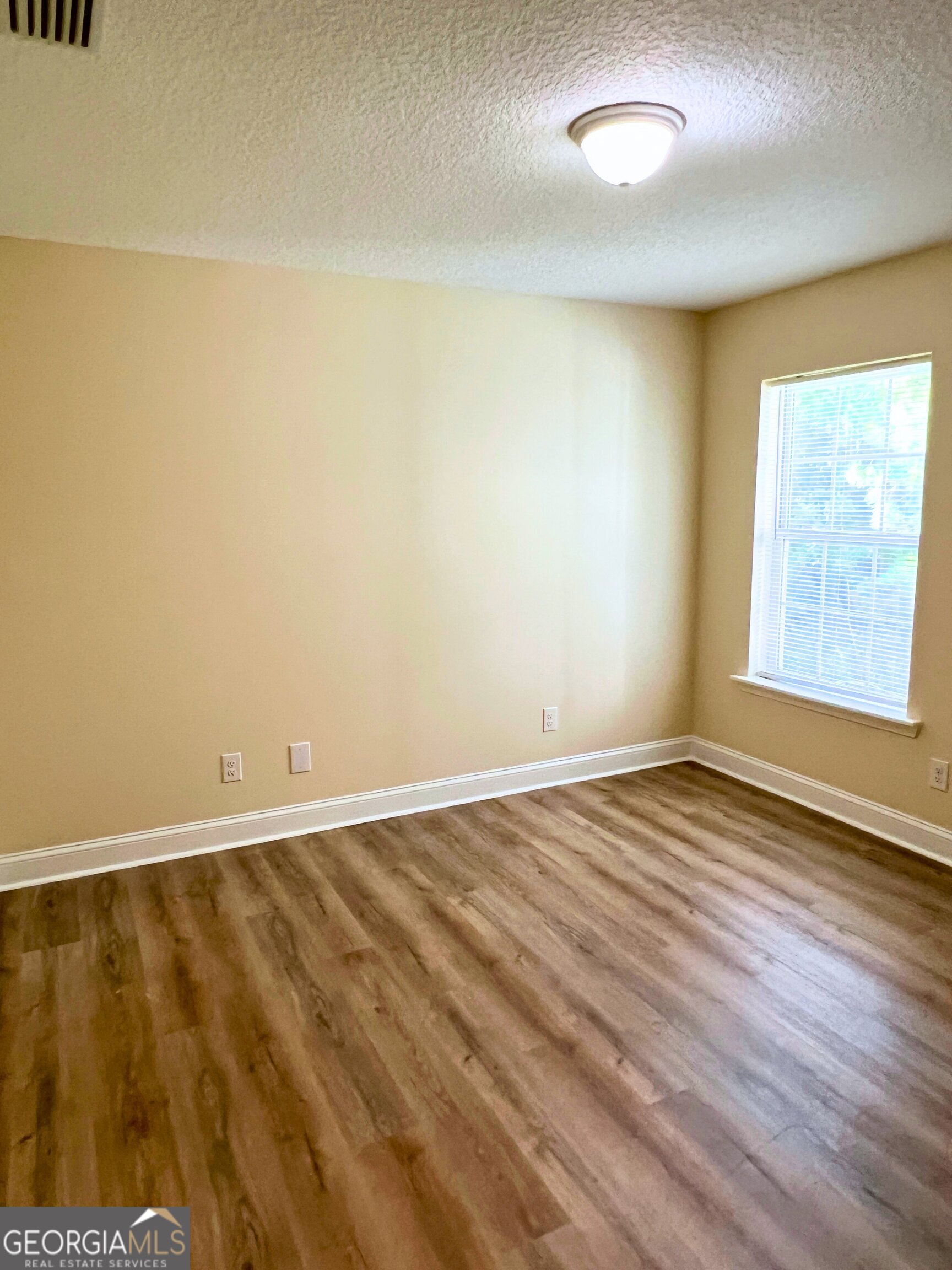 822 Davis Avenue Kingsland, GA 31548 - Photo 21 of 24 an empty room with wooden floor and windows