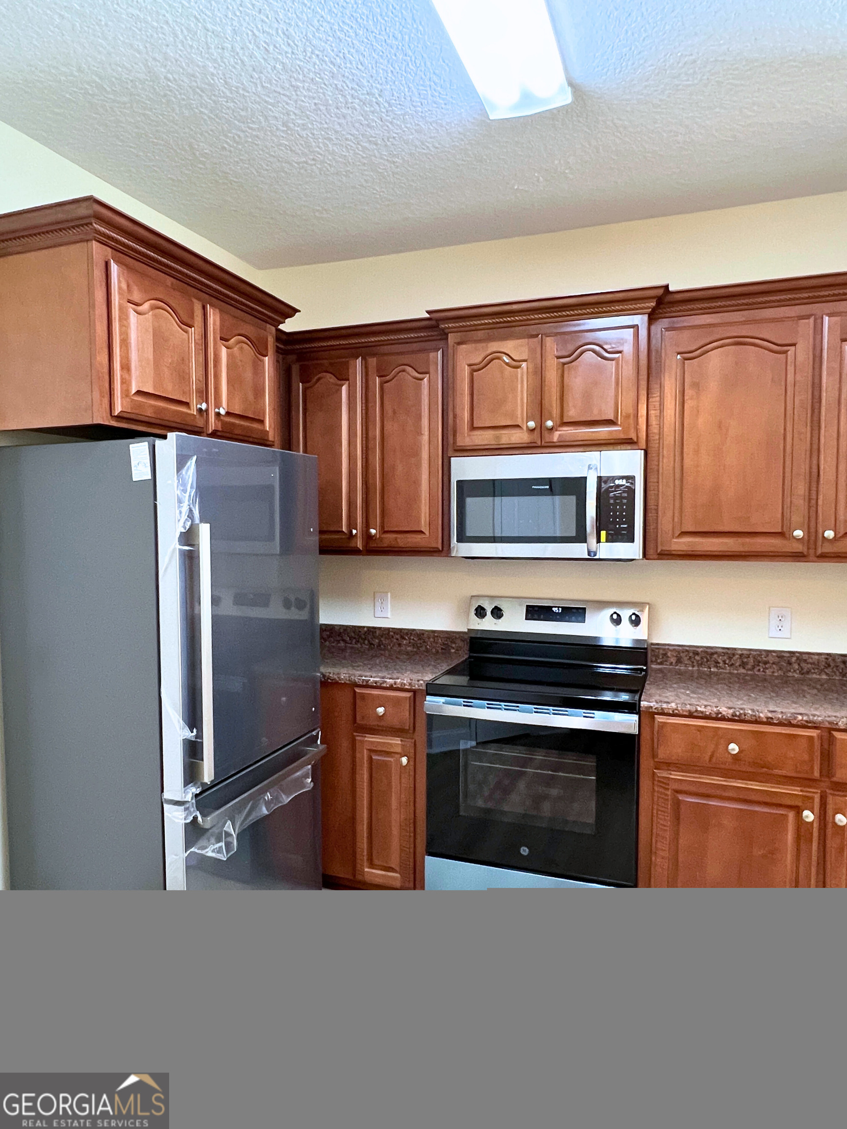 822 Davis Avenue Kingsland, GA 31548 - Photo 6 of 24 a kitchen with stainless steel appliances granite countertop a stove top oven a sink dishwasher a refrigerator and cabinets with wooden floor