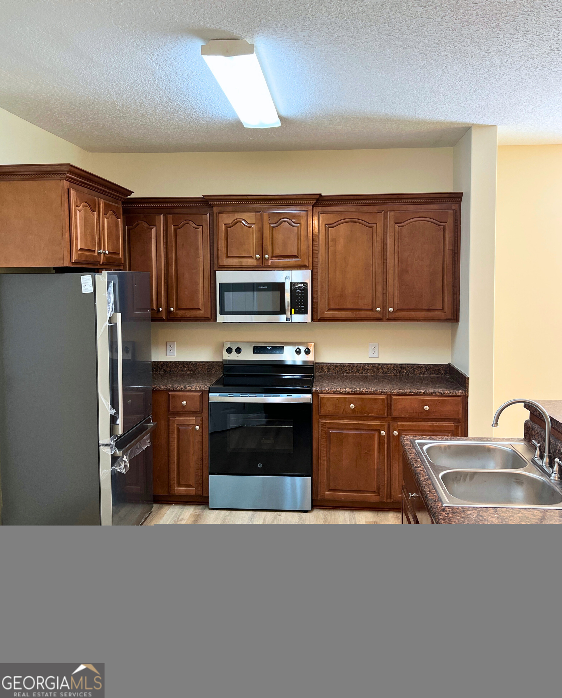 822 Davis Avenue Kingsland, GA 31548 - Photo 7 of 24 a kitchen with stainless steel appliances granite countertop a refrigerator stove and sink