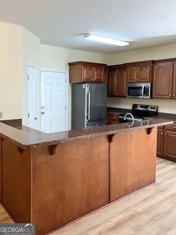 a kitchen with stainless steel appliances granite countertop a stove a sink and a refrigerator