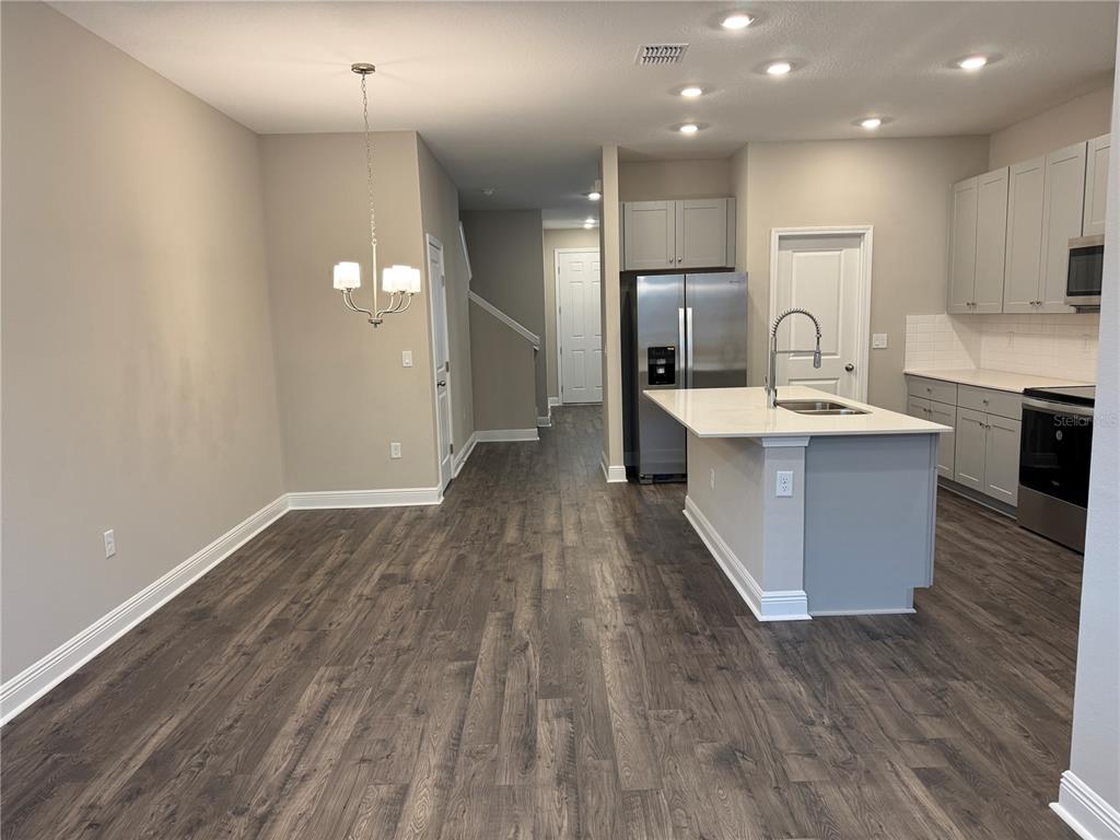 16434 Hamlin Hills Road Winter Garden, FL 34787 - Photo 12 of 50 a large kitchen with kitchen island a sink stainless steel appliances and cabinets