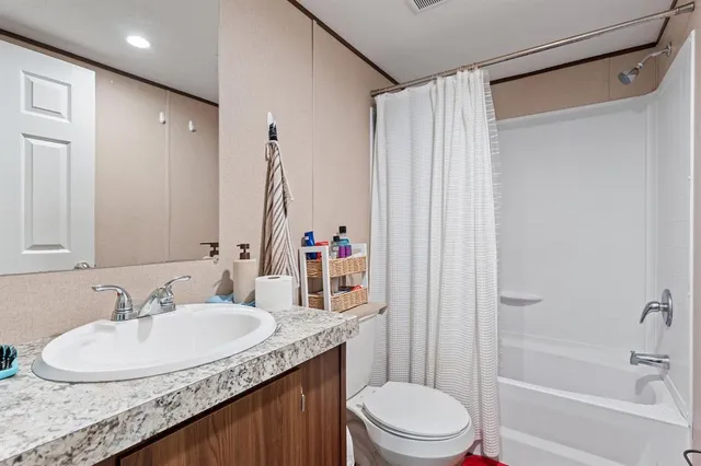 a bathroom with a granite countertop sink toilet and shower