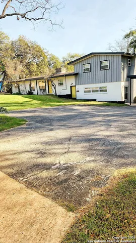 a view of houses with yard and road