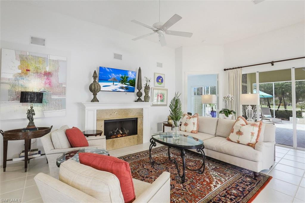 4080 Trinidad Way Naples, FL 34119 - Photo 11 of 35 a living room with furniture a flat screen tv and a fireplace