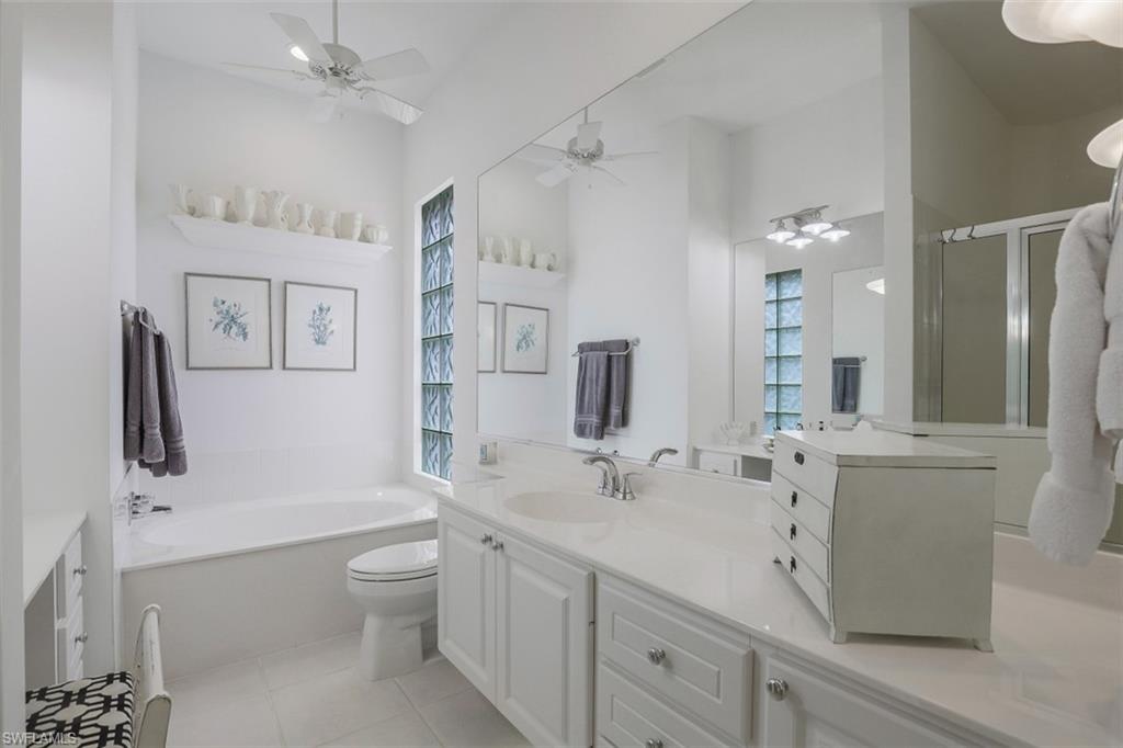 4080 Trinidad Way Naples, FL 34119 - Photo 14 of 35 a spacious bathroom with a double vanity sink toilet mirror and bathtub