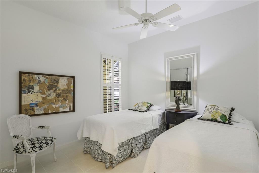 4080 Trinidad Way Naples, FL 34119 - Photo 16 of 35 a bedroom with two beds and a large mirror