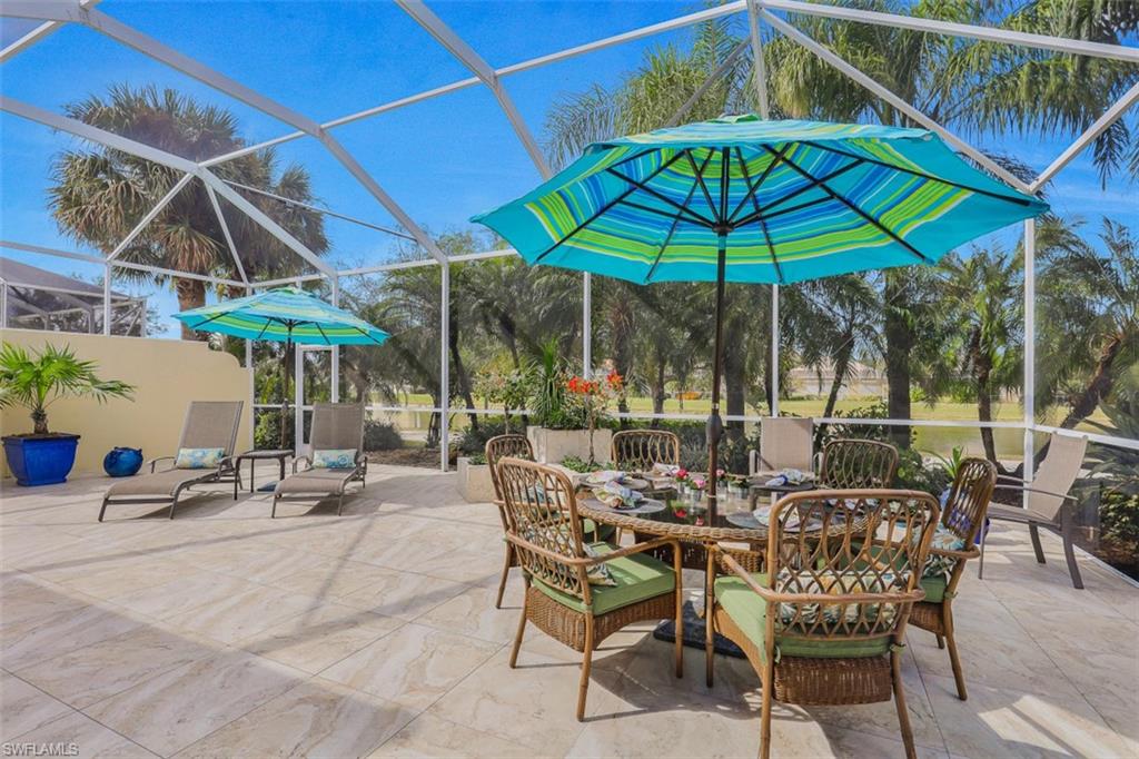 4080 Trinidad Way Naples, FL 34119 - Photo 21 of 35 a view of patio with chairs and table under an umbrella