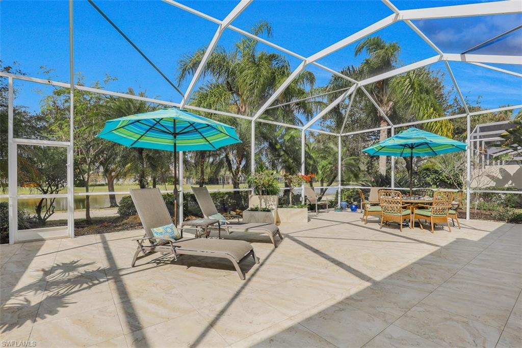 4080 Trinidad Way Naples, FL 34119 - Photo 22 of 35 a view of the patio with a table and chairs under an umbrella