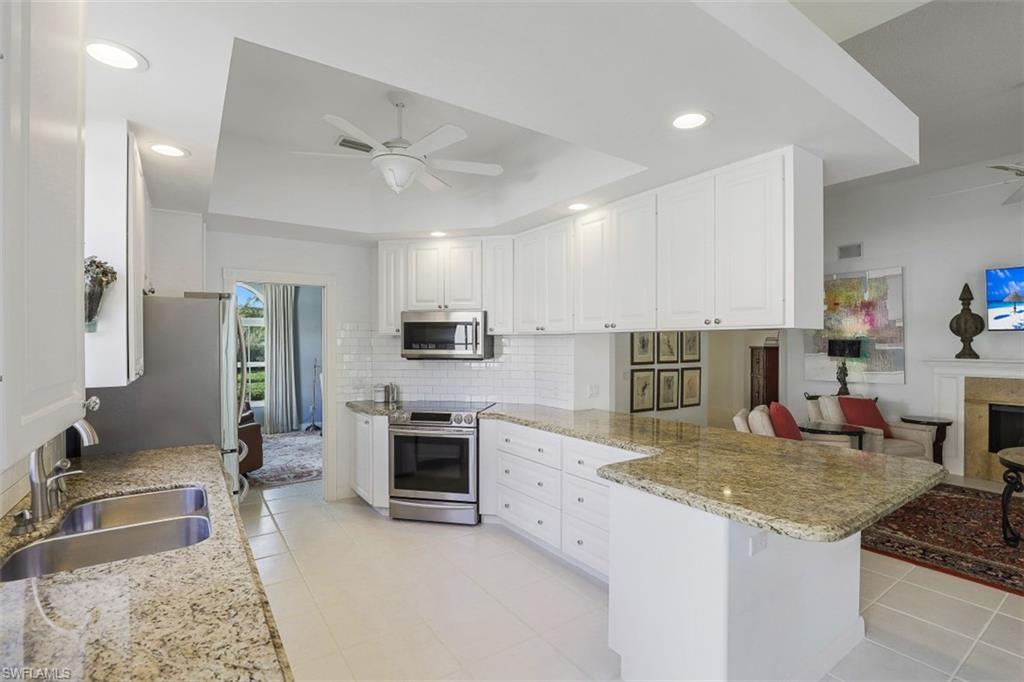 4080 Trinidad Way Naples, FL 34119 - Photo 4 of 35 a kitchen with stainless steel appliances granite countertop a sink stove and refrigerator