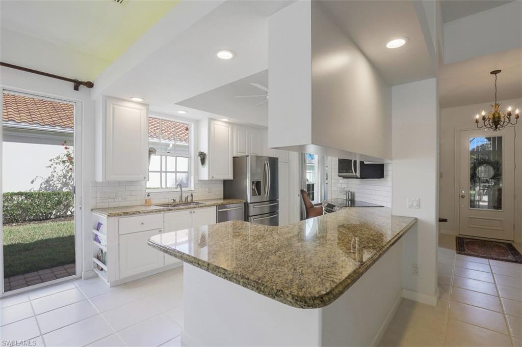 4080 Trinidad Way Naples, FL 34119 - Photo 5 of 35 a kitchen with stainless steel appliances granite countertop a sink refrigerator and cabinets