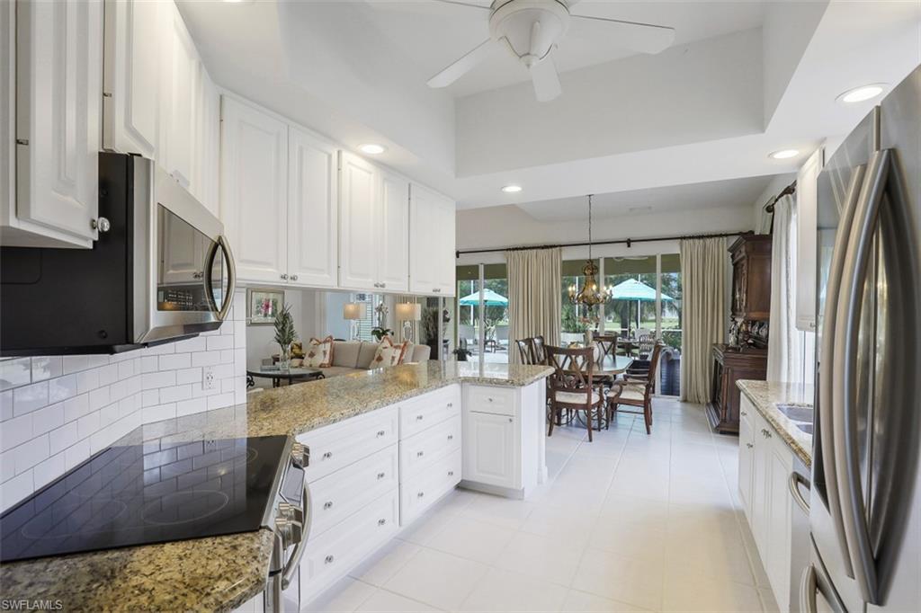4080 Trinidad Way Naples, FL 34119 - Photo 6 of 35 a kitchen with stainless steel appliances kitchen island granite countertop a refrigerator and a stove top oven