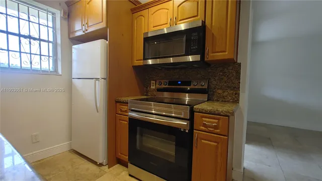 a kitchen with a stove microwave and fridge