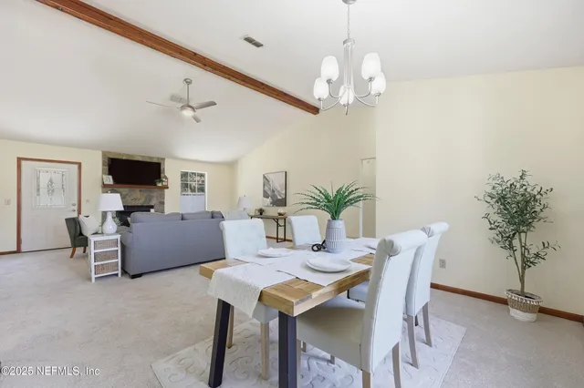 a view of a dining room with furniture and chandelier