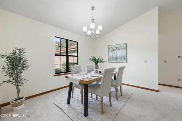 a view of a dining room with furniture and chandelier