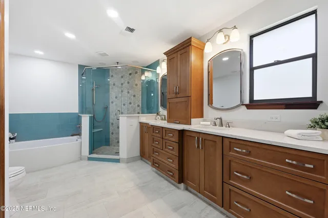 a spacious bathroom with a tub sink and mirror
