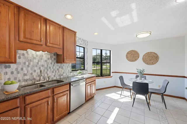 a kitchen with a sink a stove cabinets and dining table