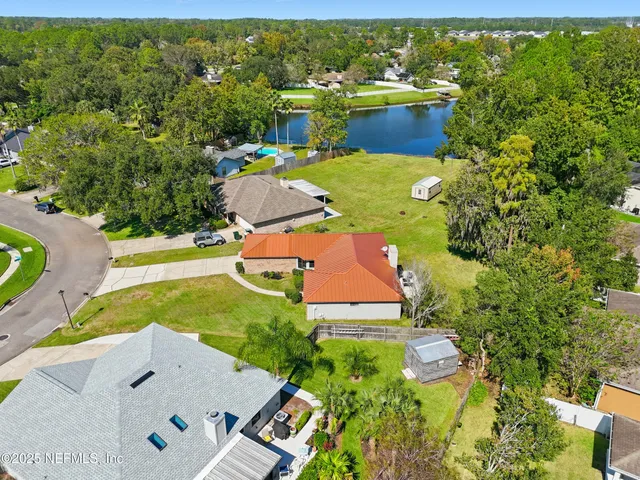 an aerial view of residential house with outdoor space and trees all around