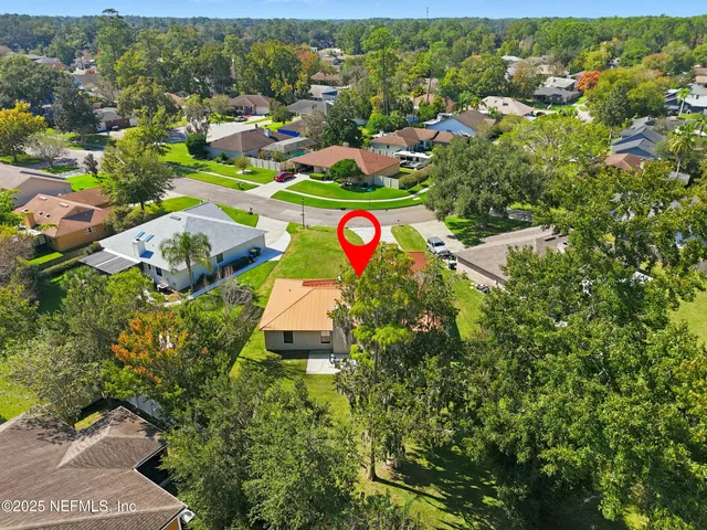 an aerial view of a house with a garden and lake view