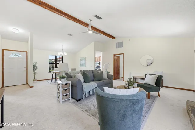 a living room with furniture and a potted plant