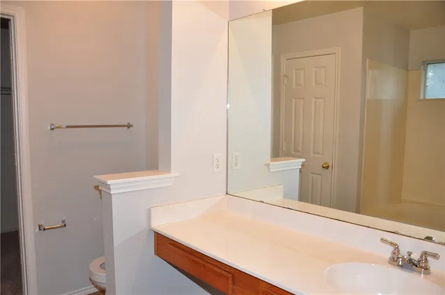 a bathroom with a sink a toilet and a mirror