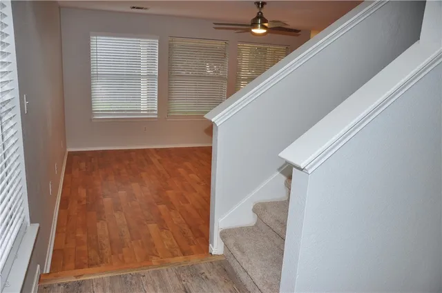 an entryway with wooden floor and staircase