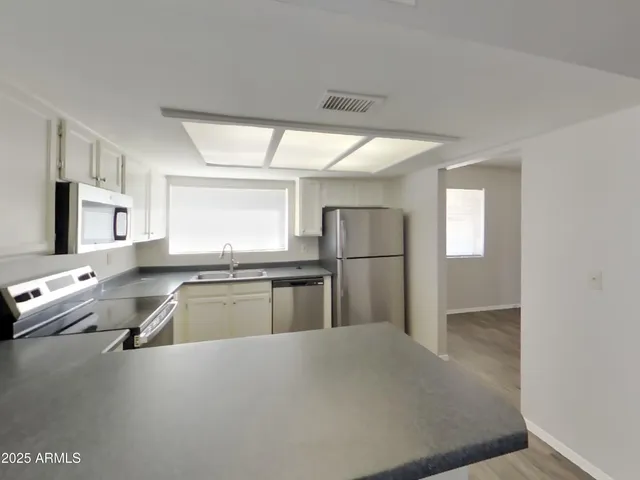 a kitchen with granite countertop a refrigerator and a sink