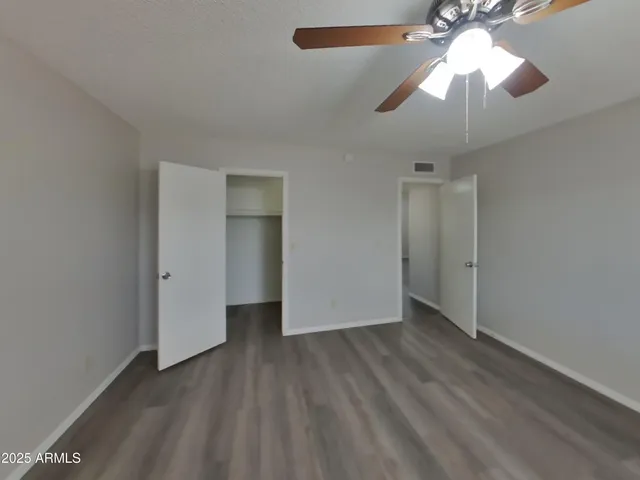 a view of an empty room with a chandelier fan