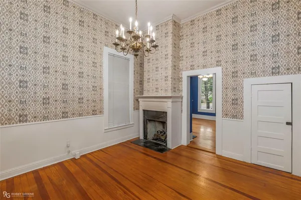 a view of a livingroom with a fireplace wooden floor and a chandelier