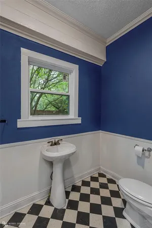 a bathroom with a sink a toilet and a window