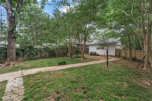 a view of a house with a backyard and a tree