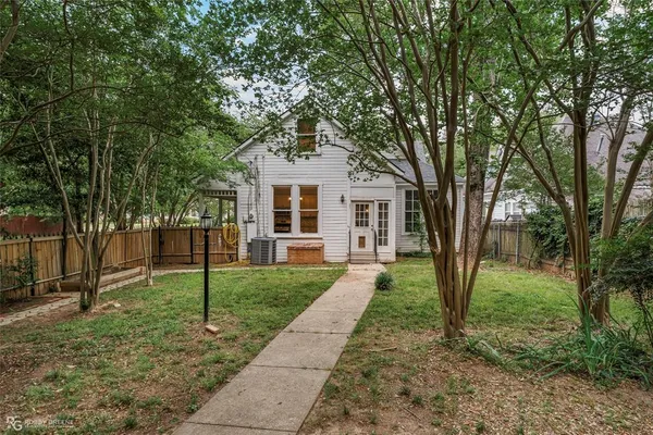 a view of a yard in front of a house with a big yard and large trees