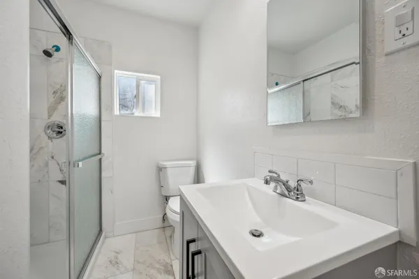 a bathroom with a sink and mirror with toilet