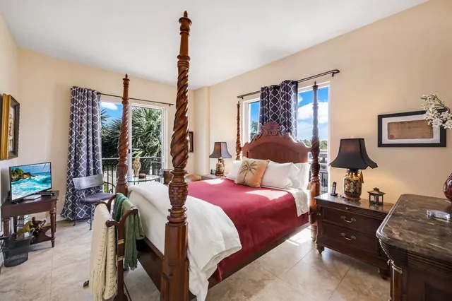 a bedroom with a bed large window and couch