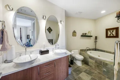 a bathroom with a double vanity sink mirror and toilet