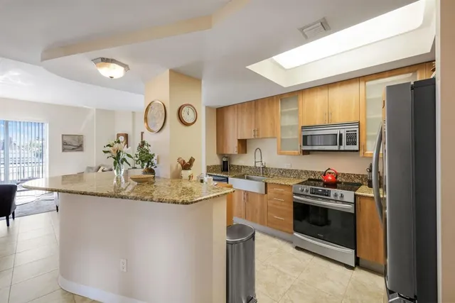 a kitchen with stainless steel appliances granite countertop a stove a sink and a refrigerator