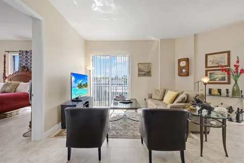 a living room with furniture a computer on the desk and a window