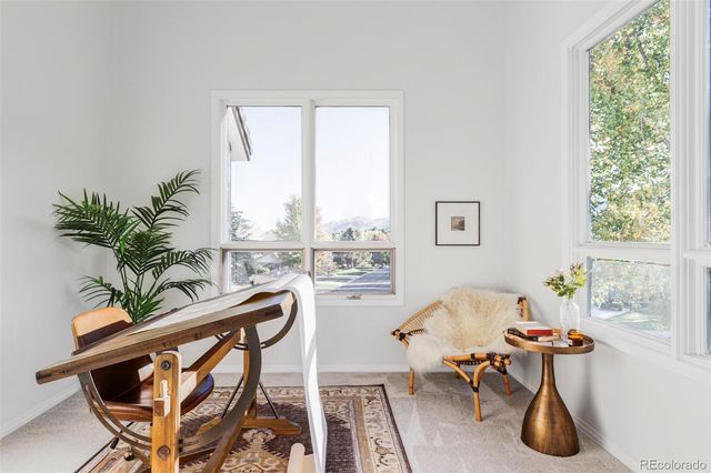 a living room with furniture a potted plant and a large window