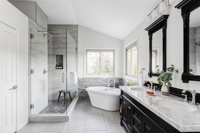 a bathroom with a double vanity sink a mirror and a bathtub